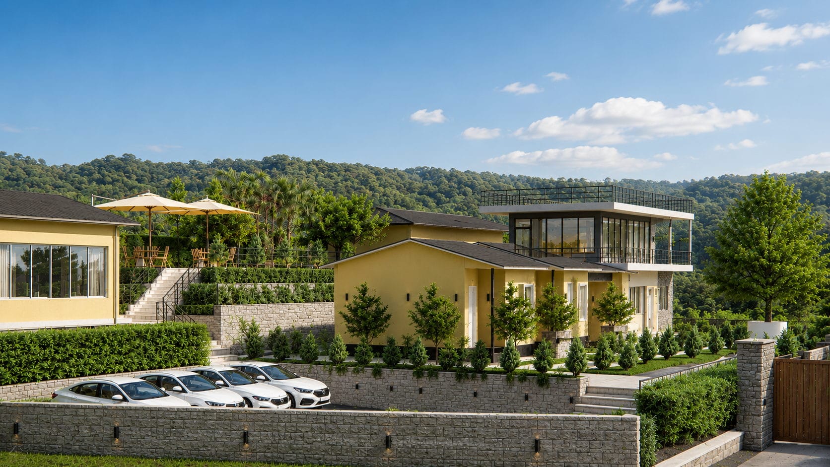 The resort’s villas stepping down landscaped stone terraces, with forested hills rising behind them.