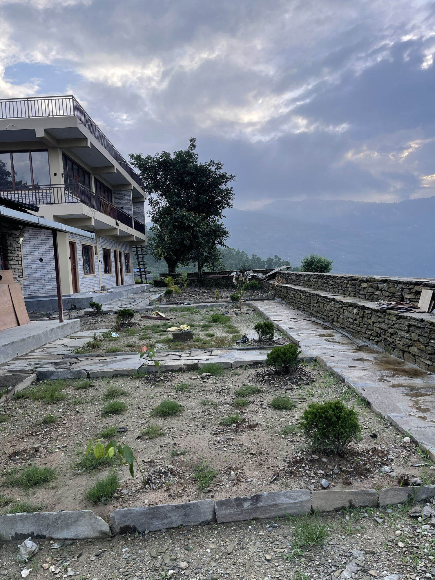The resort building at dusk, above a newly planted garden edged with dry-stone terracing.