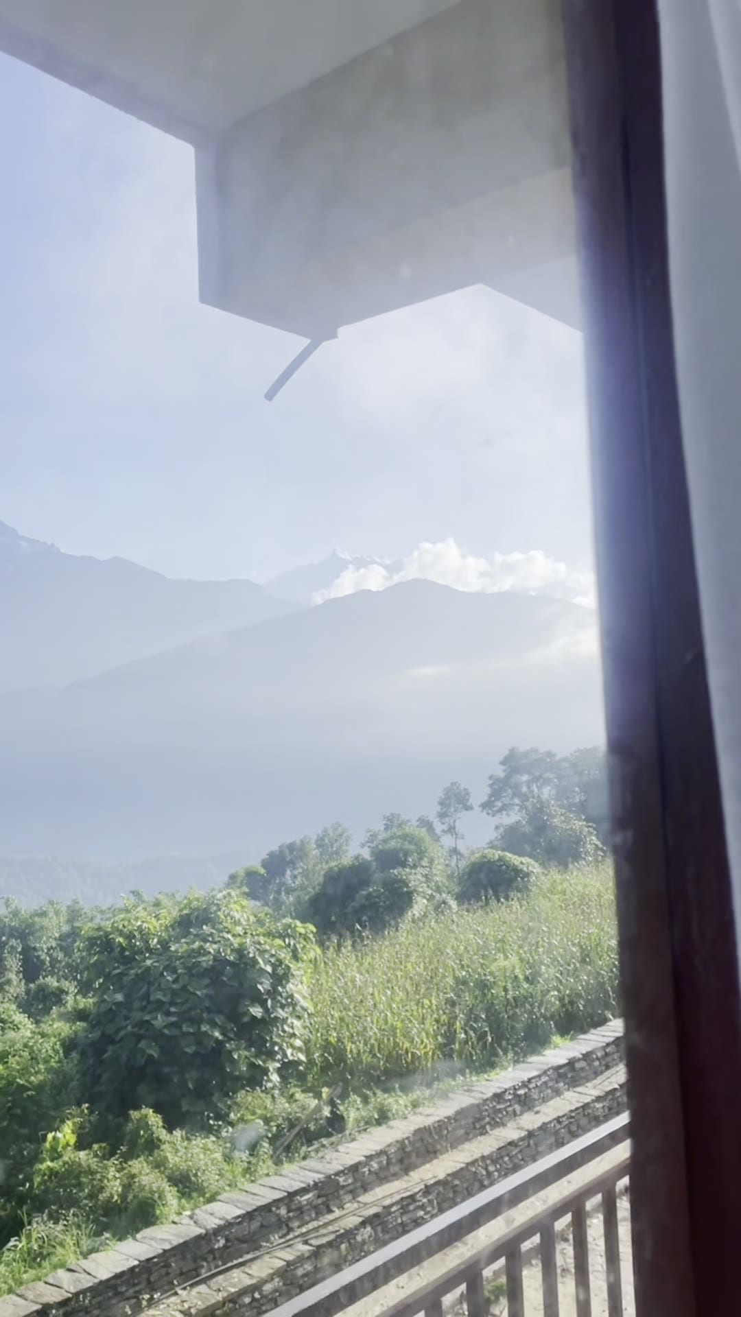 The mountains seen from beneath the eave of the resort terrace, with mist in the valley.